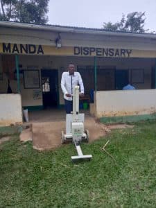 Healthcare professional pushes X-ray machine at a medical camp in Kenya